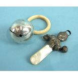 A late-Victorian baby's rattle in the form of a child's face, with four hanging bells and mother-