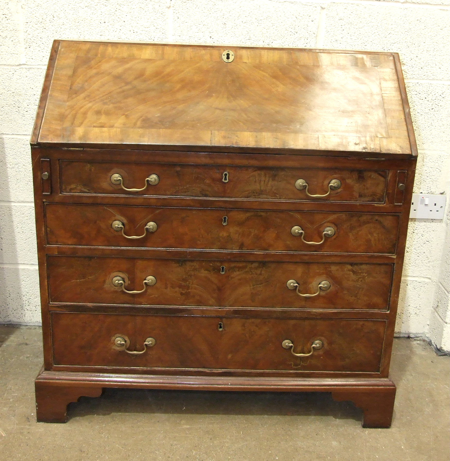 A George III mahogany bureau, the fall front with fitted interior, above four graduated cockbeaded