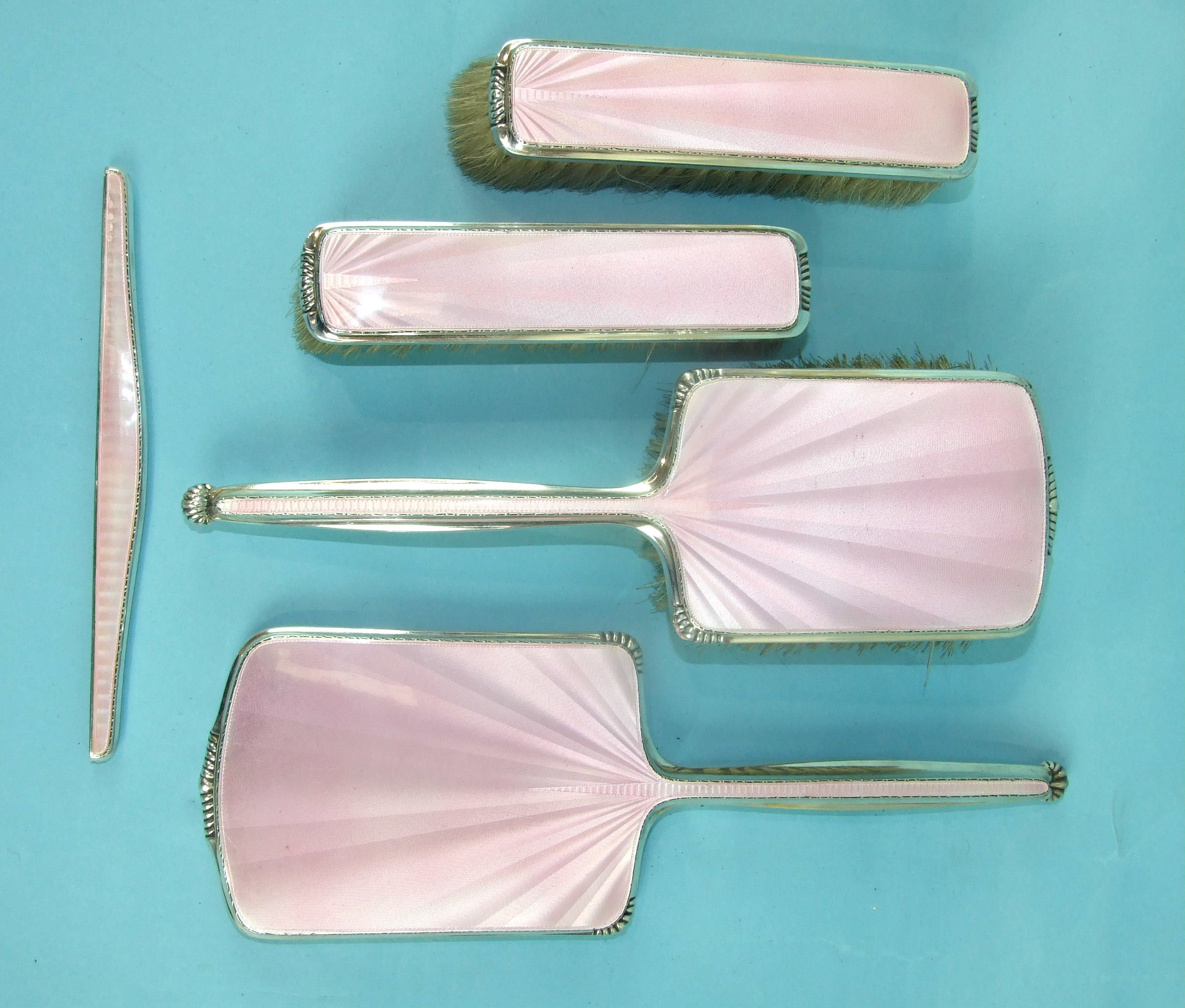 A mid-20th century pink-enamelled and silver dressing table set comprising: hair brush, two