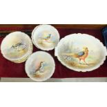 A set of twelve Limoges painted porcelain plates and serving dish, each decorated with a bird and