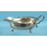 A George II Scottish cream or sauce boat on three hoof feet, with a shaped and chased rim and scroll