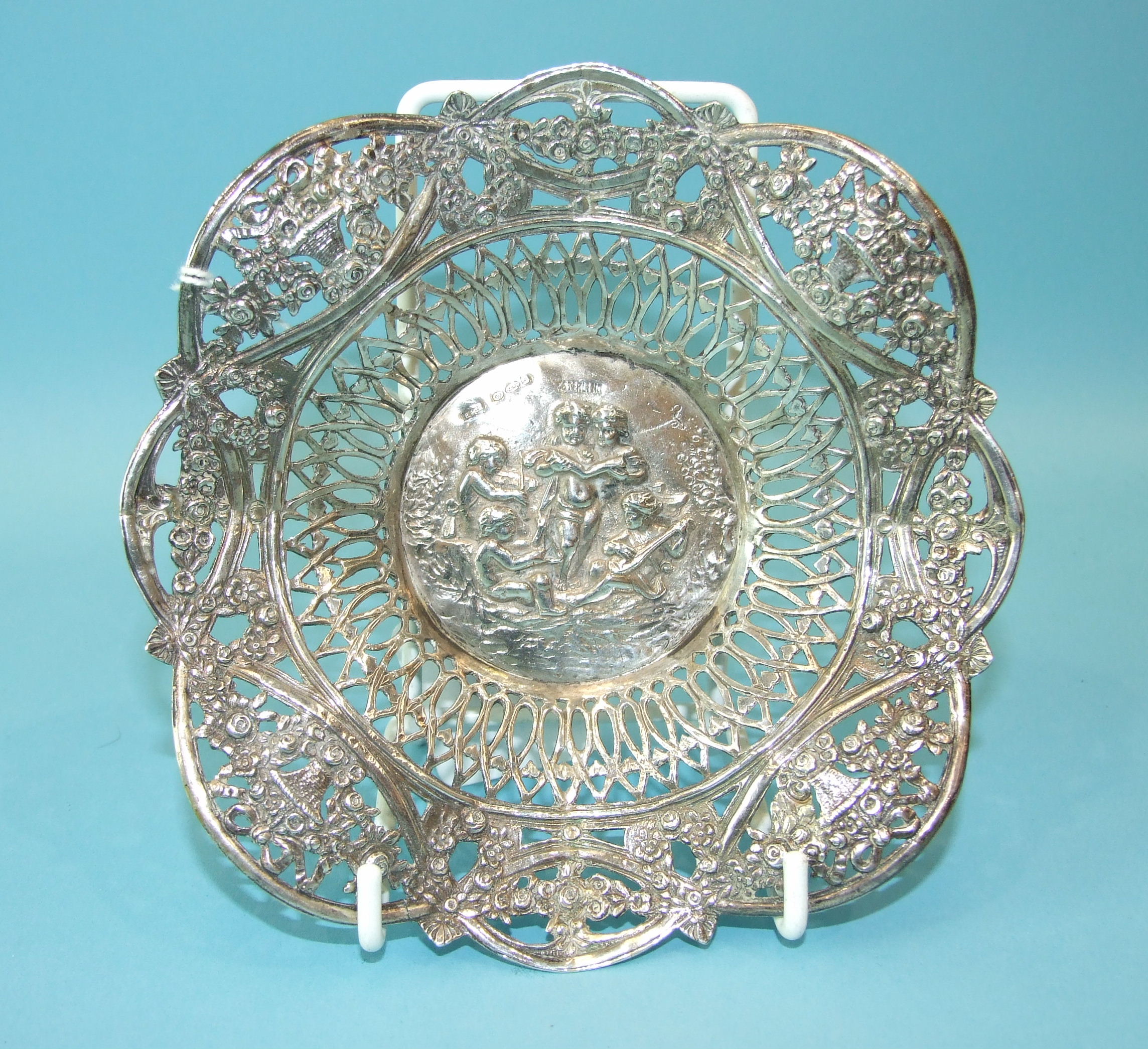 A Continental pierced circular dish, the centre embossed with putti playing musical instruments - Image 3 of 3