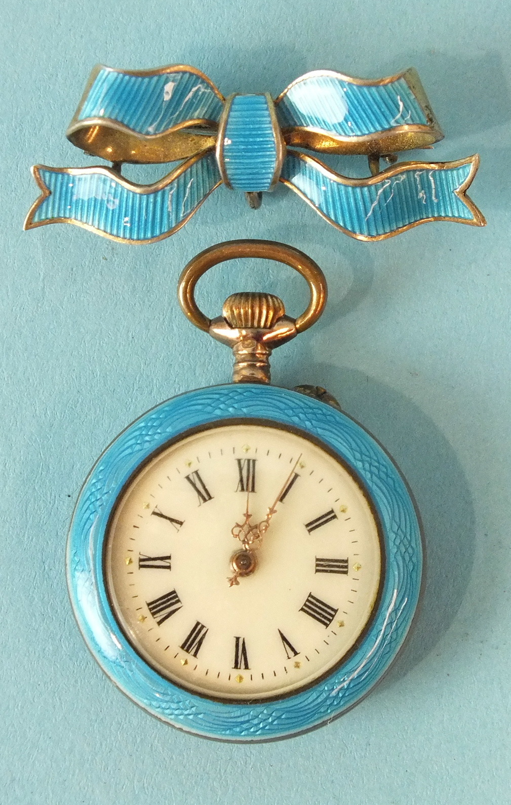 A ladies Swiss keyless pocket watch, the white enamel dial with Roman numerals within blue guilloche