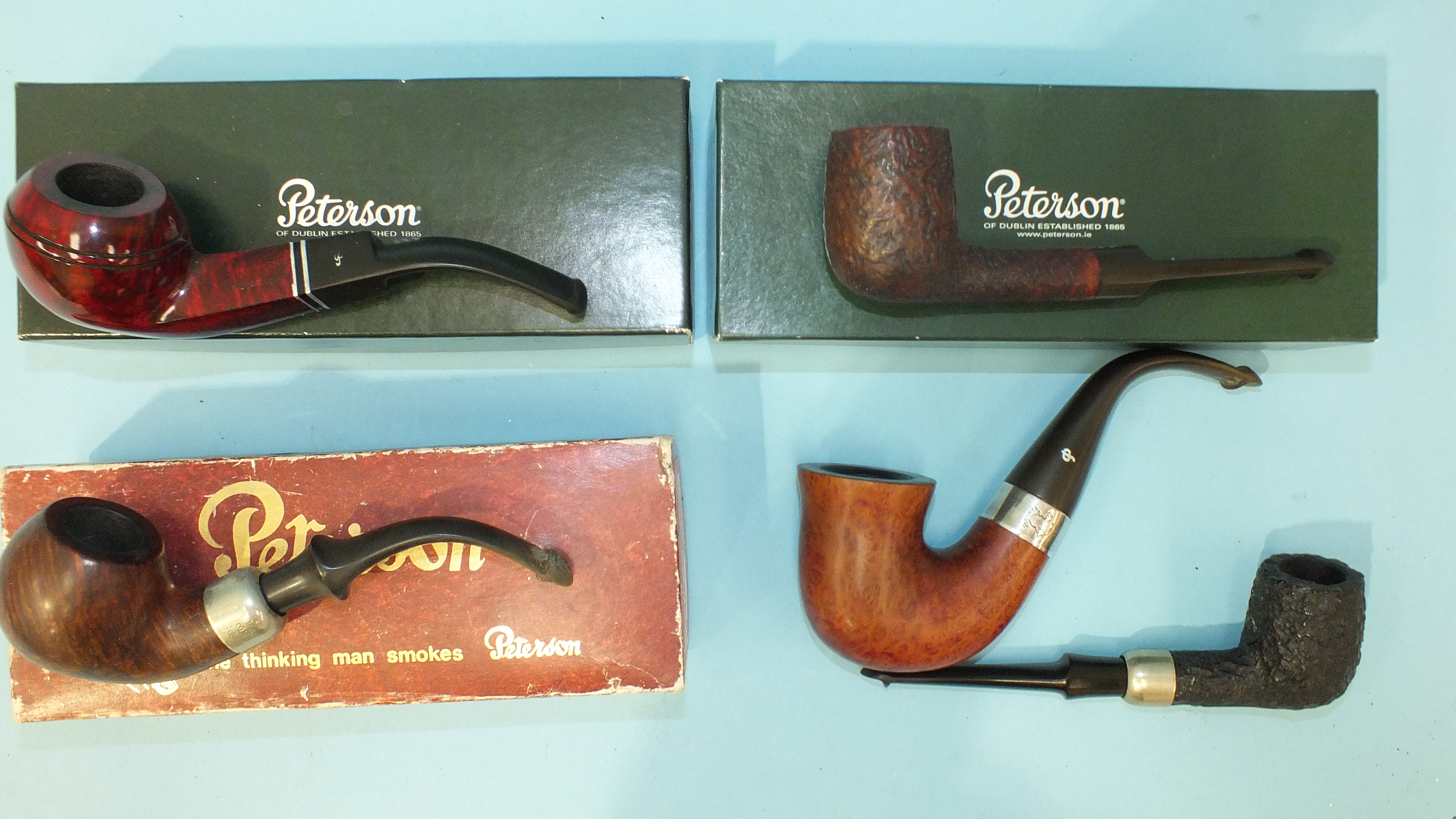 A Petersons Sherlock Holmes silver-mounted pipe and four other Petersons pipes, three boxed, (5).