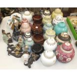 A collection of various modern coloured ceramic ginger jars and covers, with wooden stands, modern