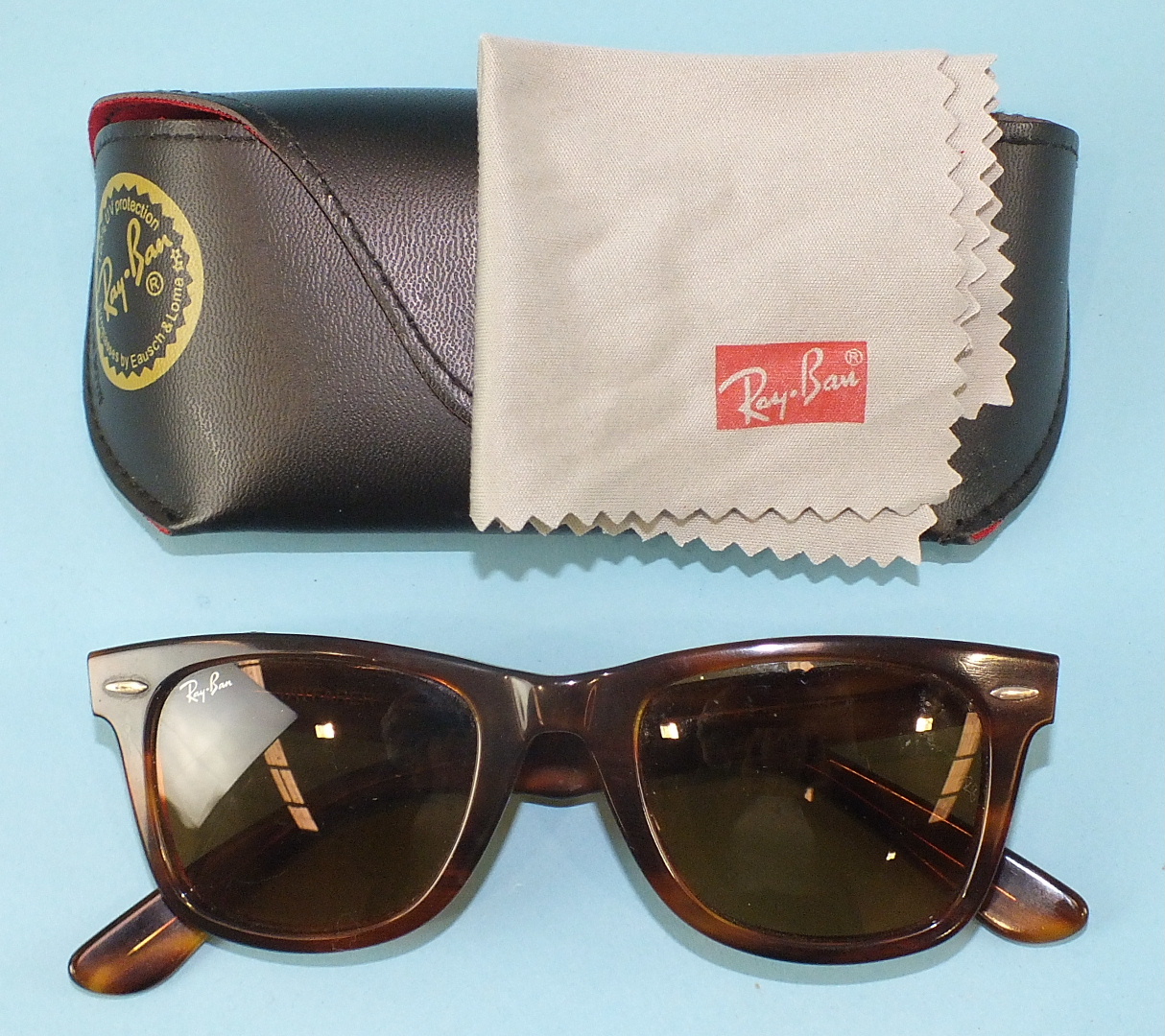 Ray-Ban, a pair of Wayfarer sunglasses with tortoiseshell-style frames and case.