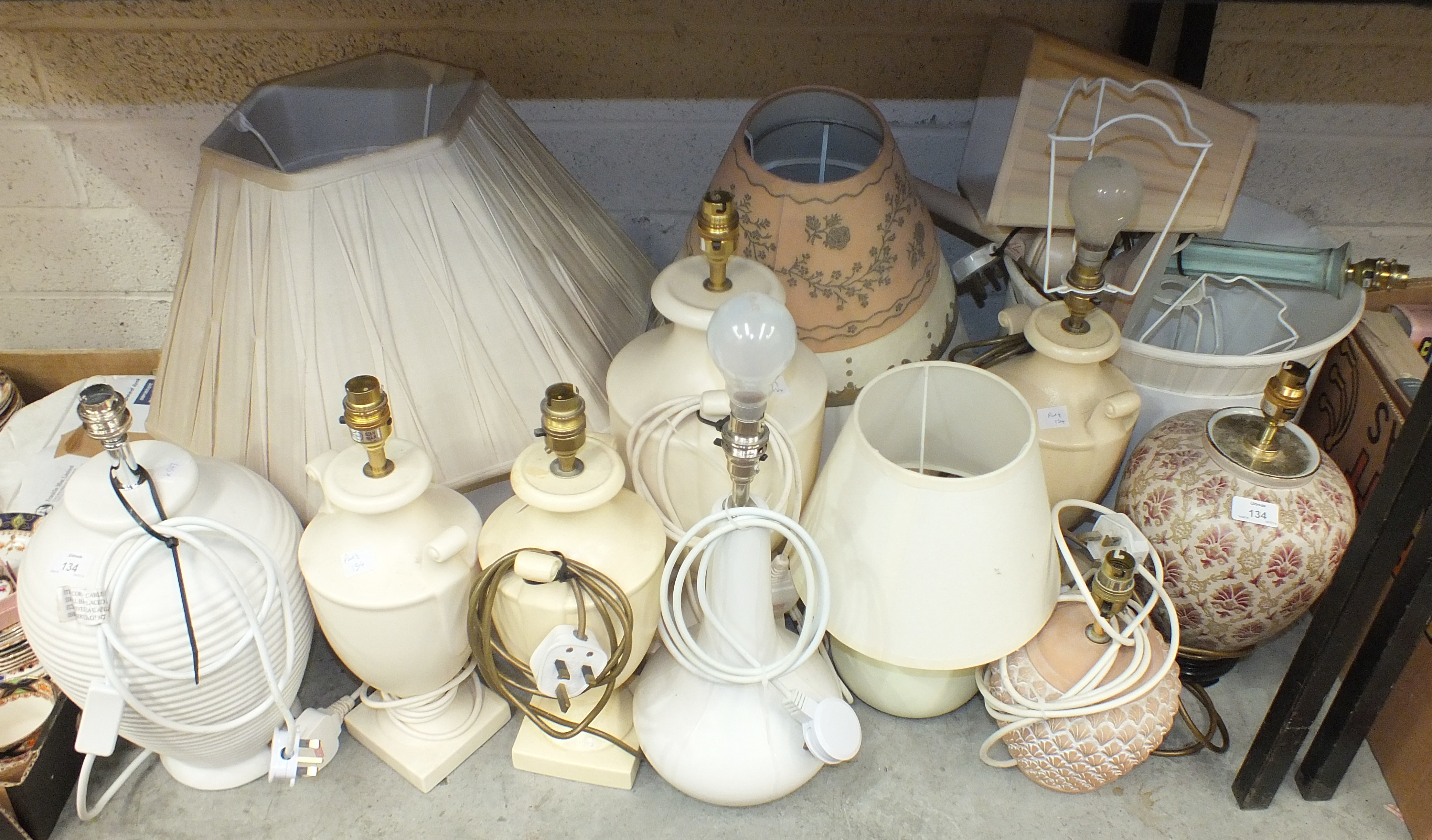 A collection of various ceramic and other table lamps with shades.