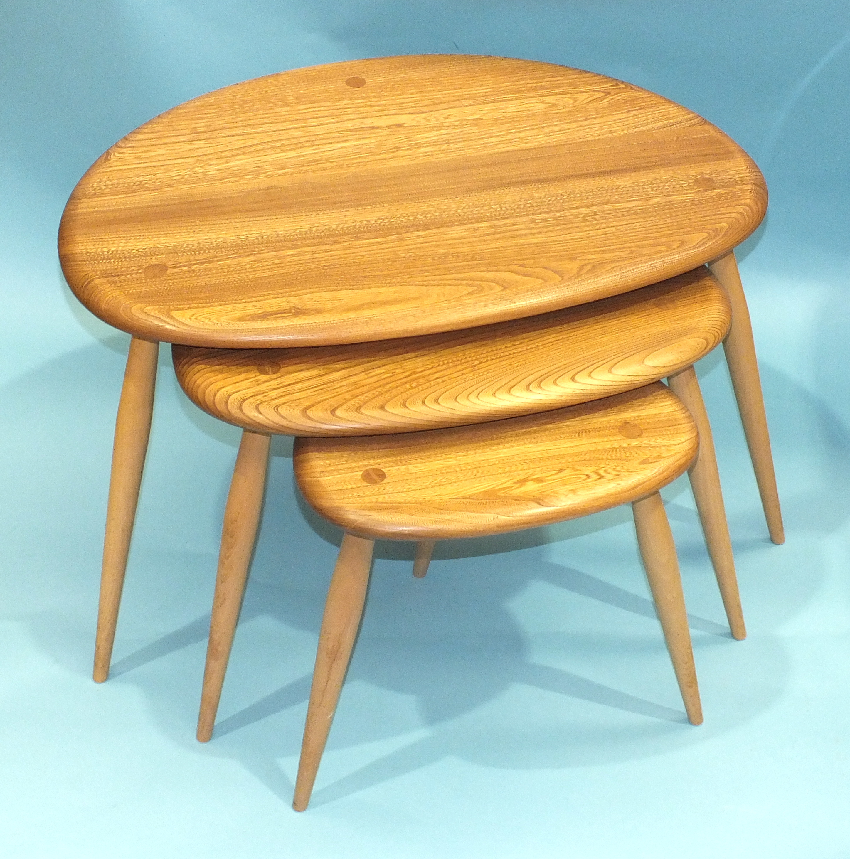 An Ercol nest of three light elm and beech 'Pebble' tables, largest 64cm wide, 41cm high. - Image 2 of 2