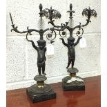 A pair of gilt metal two-branch table-top candle holders, having a cherub-figured column, on