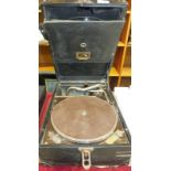 An HMV portable gramophone together with a small collection of 78RPM records.