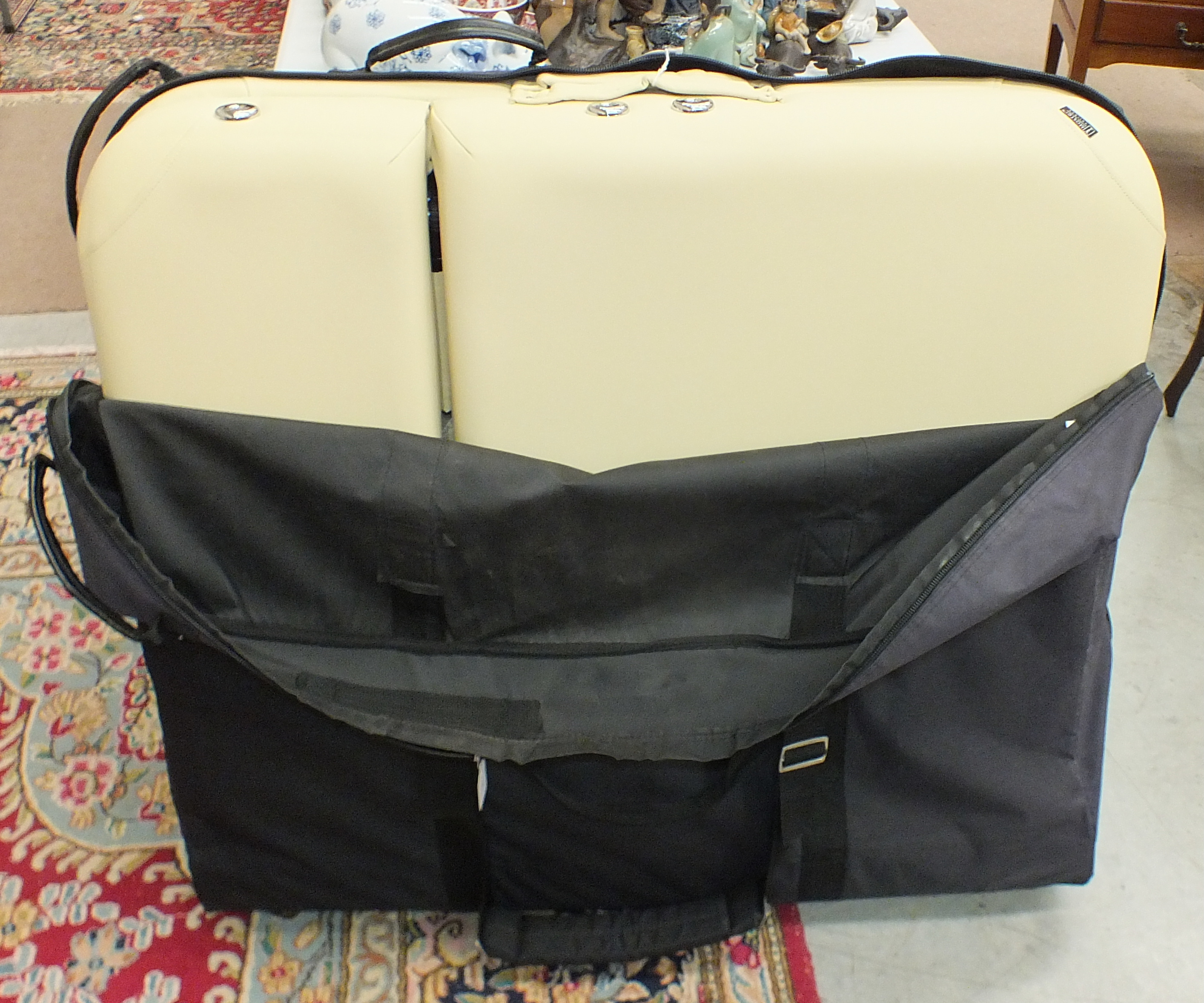 A 'Master' folding massage table in protective carrying case with wheels.