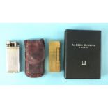 A Dunhill 'Unique' lighter numbered 480735, in pouch and a Dunhill gold-plated lighter in worn