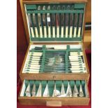 A part-canteen of cutlery contained in an oak fitted box with drawer.