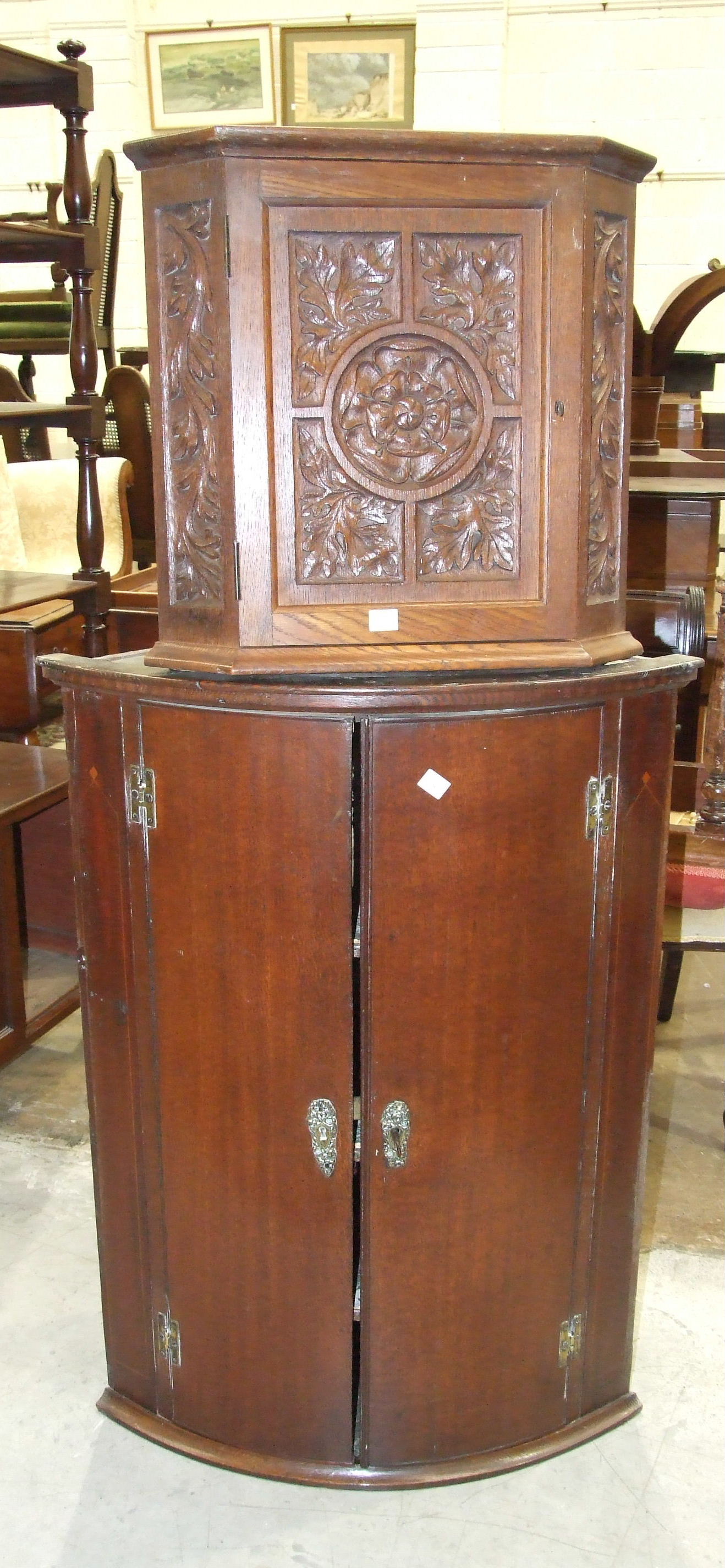 A Georgian oak bow-fronted hanging wall cupboard, 66cm wide, 93cm high and an Edwardian carved oak