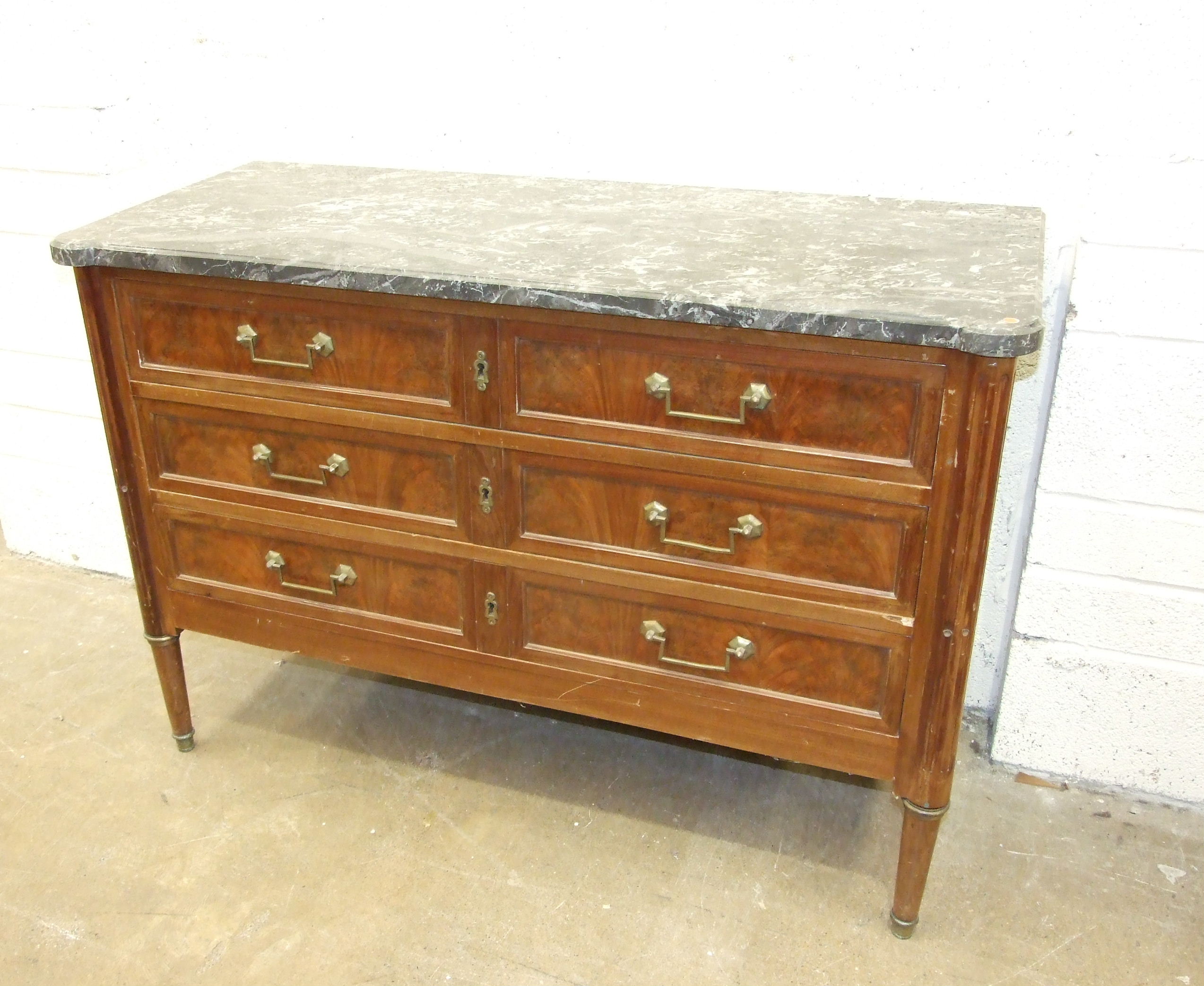 A late-19th century French walnut chest of three long drawers, within stock-fluted pilasters on