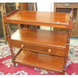 An Edwardian walnut three-tier dumb waiter, the centre tier fitted with a drawer, 92cm wide, 104cm