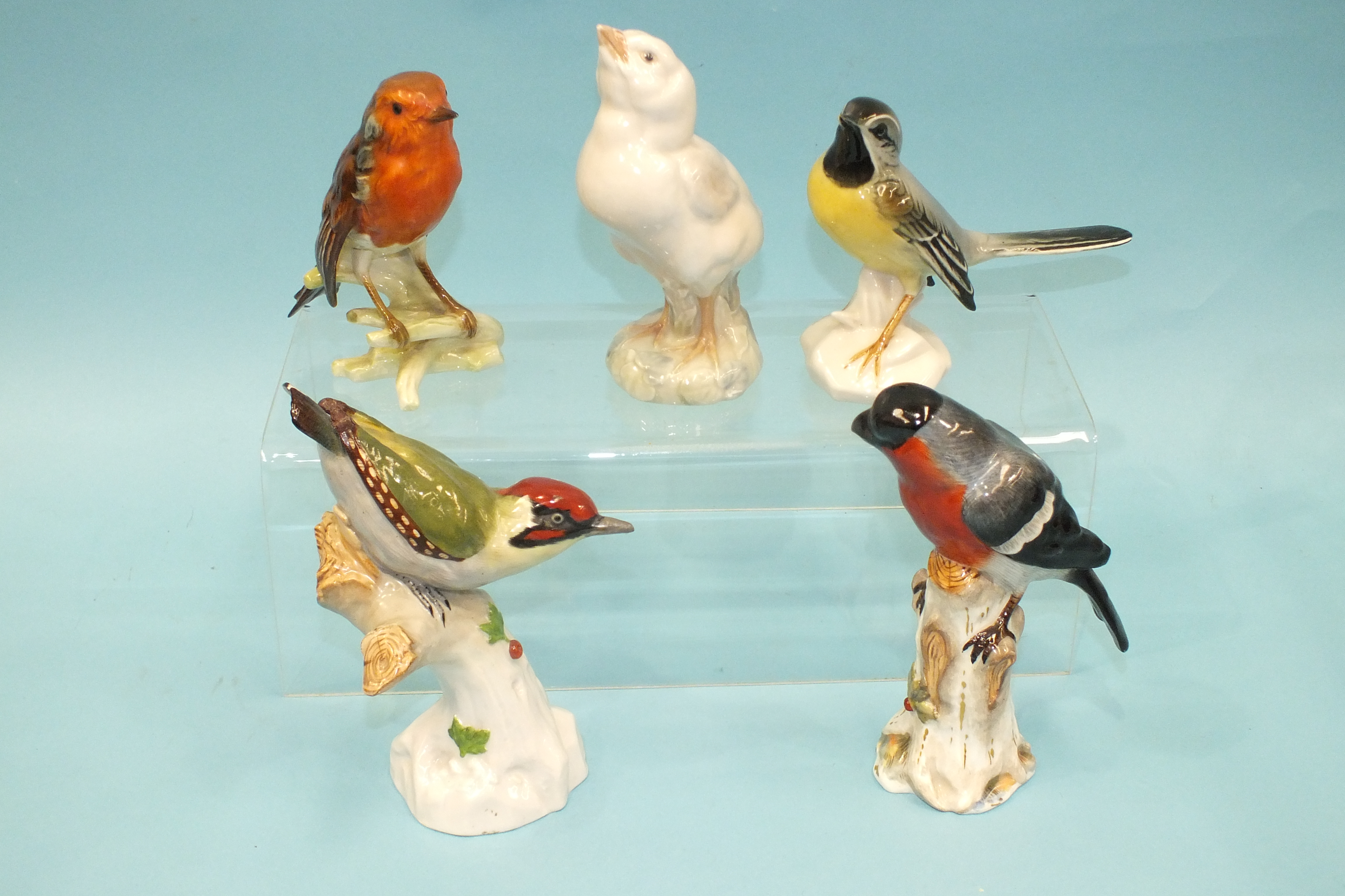 A 20th century porcelain model of a bullfinch perched on a tree stump, in the Meissen style, 16cm