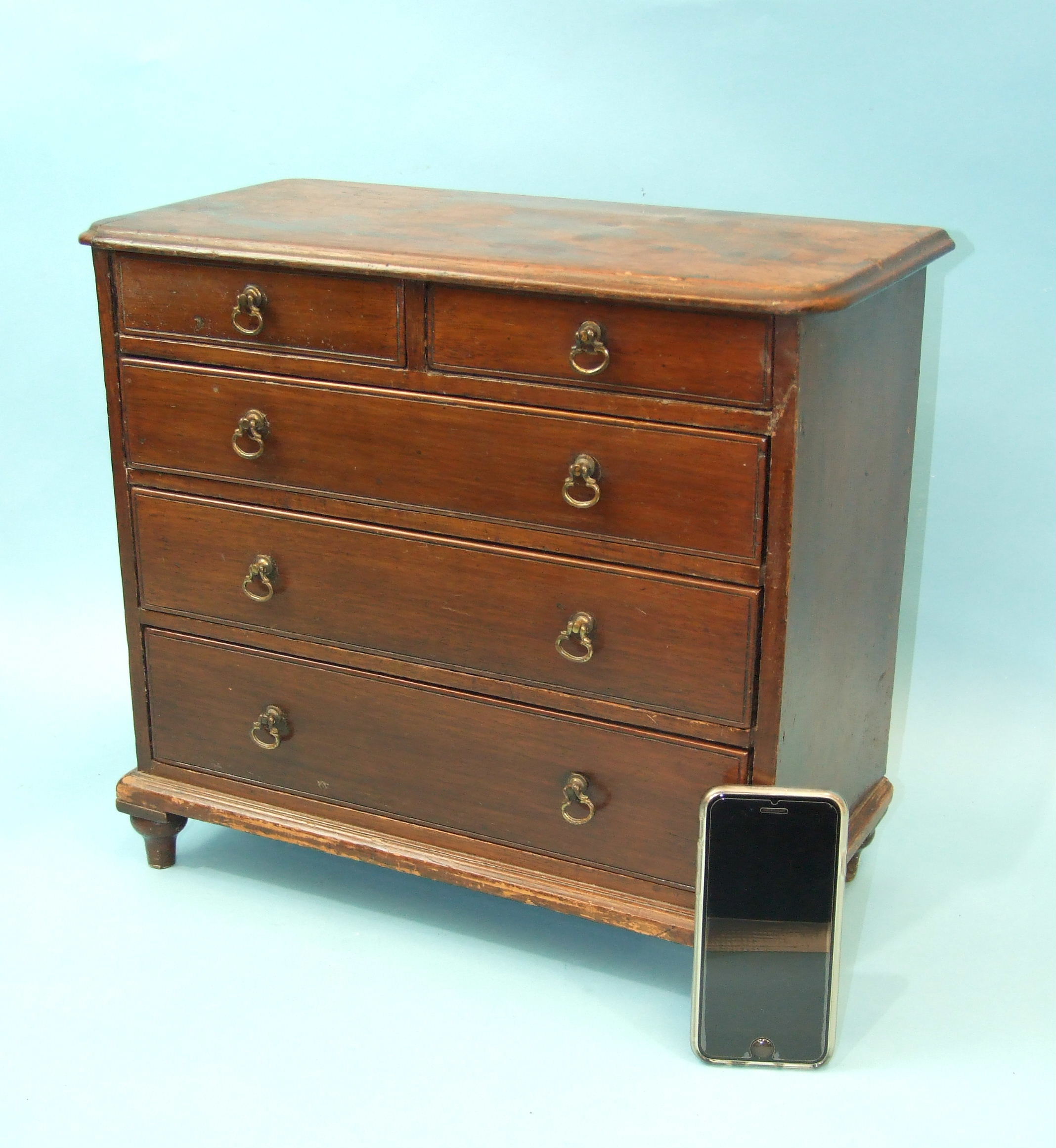 A late-19th century miniature mahogany chest of two short and three long graduated drawers, on