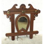 An Edwardian walnut wall-mounted hanger for riding crop and hat, with central horseshoe-shaped