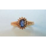 A sapphire and diamond cluster ring, set an oval sapphire within a border of diamond points on 9ct