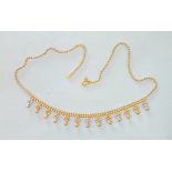 An 18ct tricolour gold fringe necklace of ball chain with twelve drops, 40cm, 12.3g.