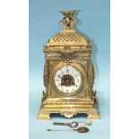 A Victorian brass decorative mantel clock with cherub finial, enamelled chapter ring and French drum