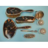 A silver and tortoiseshell-backed three-piece dressing table set, Birmingham 1927, a manicure part-