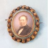 A Victorian locket-back mourning brooch with miniature of a gentleman, within blue enamelled frame
