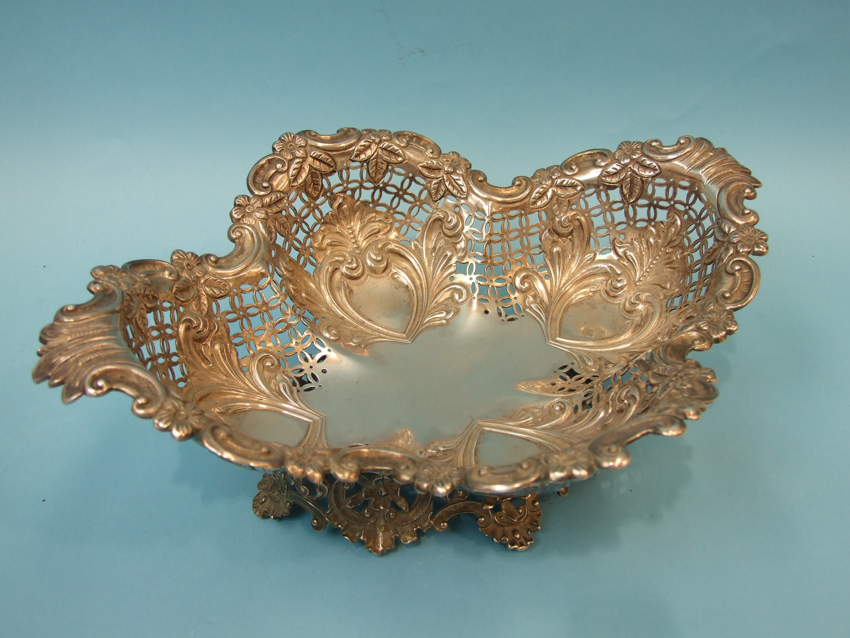 A Mappin & Webb silver cake basket, the pierced and lobed quatrefoil basket raised on elaborately-