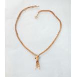 A 9ct gold necklace of two pairs of foxtail-link chains united by a gold knot, with tassel below,