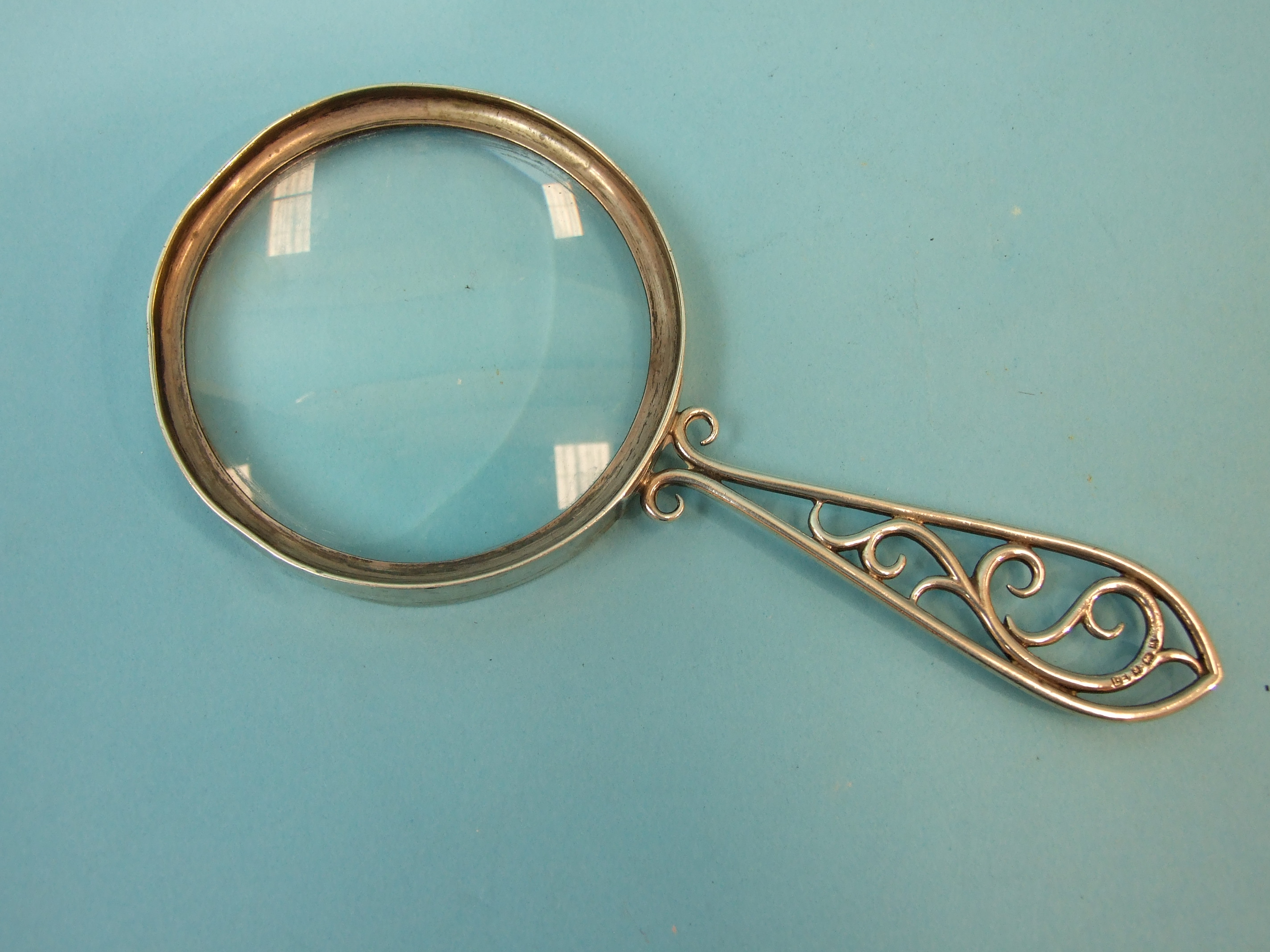 A silver magnifying glass with scrolling handle, 17cm long, maker Lawrence Emanuel, Birmingham