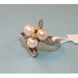 A 10ct white gold ring of asymmetric design set three cultured pearls and white stone accents,