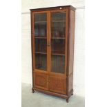 A modern Oriental hardwood display cabinet, having a pair of glazed doors above two carved doors,