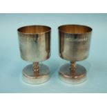 A pair of modern silver goblets of squat form, each with slightly-tapered bowl and knopped stem