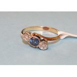 A sapphire and diamond cross-over ring set a round-cut sapphire and two 8/8-cut diamonds, in