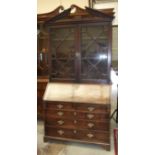 A Georgian mahogany bureau/bookcase, the pediment above a pair of astragal-glazed doors, with fall