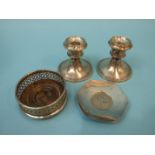 A pair of silver dwarf candlesticks, Birmingham 1919, 7.5cm high, a small silver coaster and a