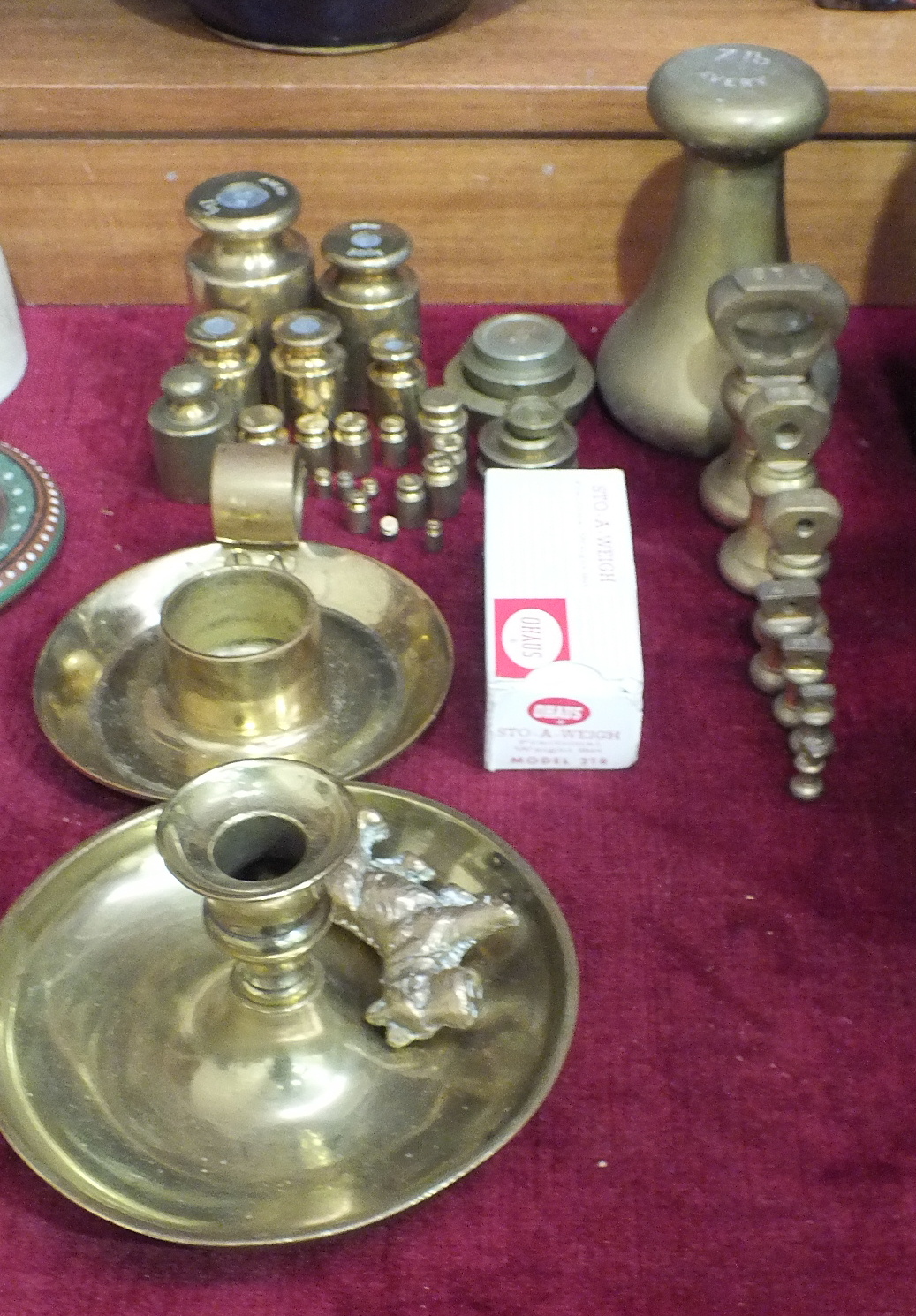 A collection of various brass weights, two brass candle holders, etc.