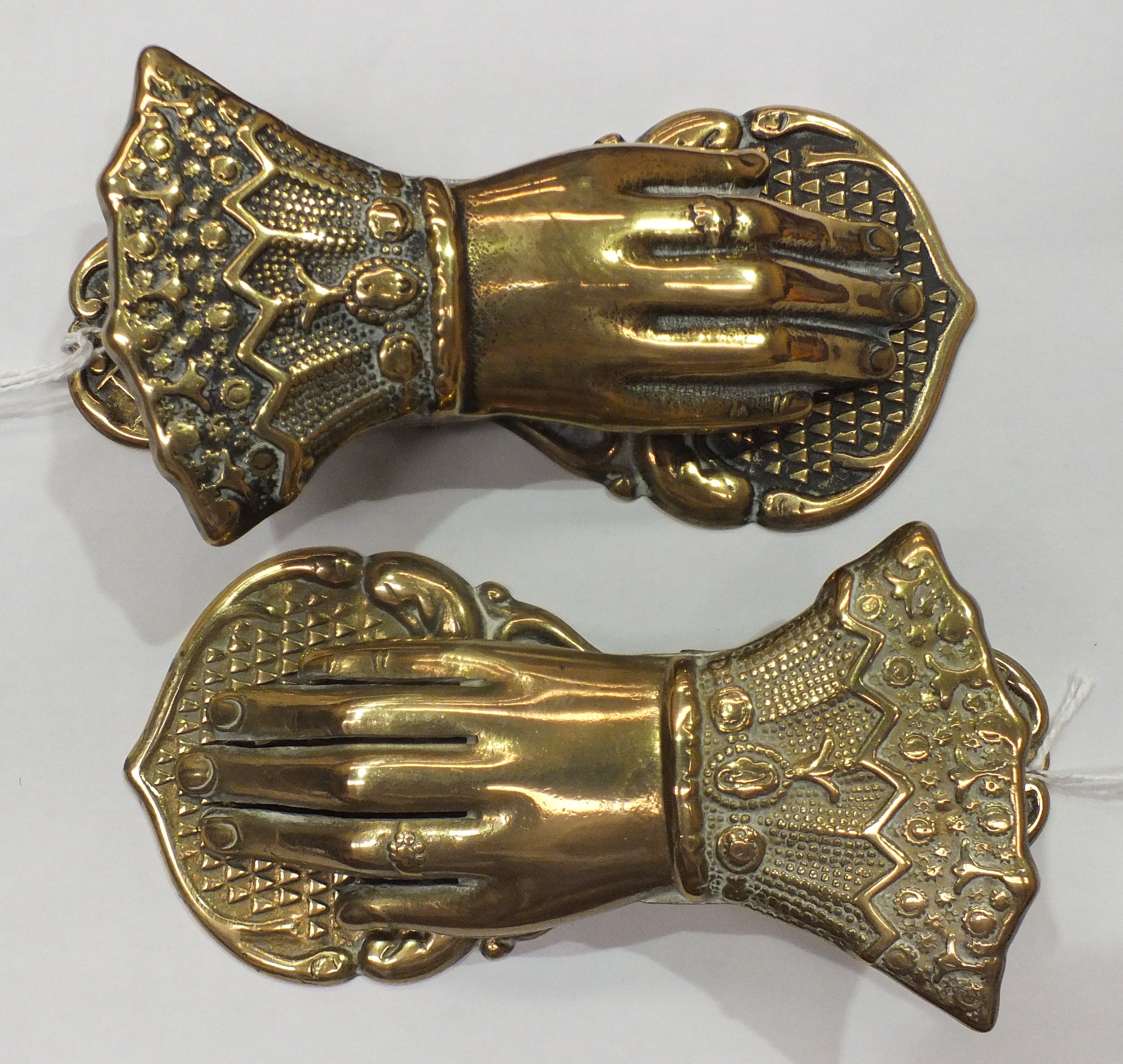 Two brass paper tidies, each in the form of a human hand, 13cm long.