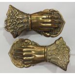 Two brass paper tidies, each in the form of a human hand, 13cm long.