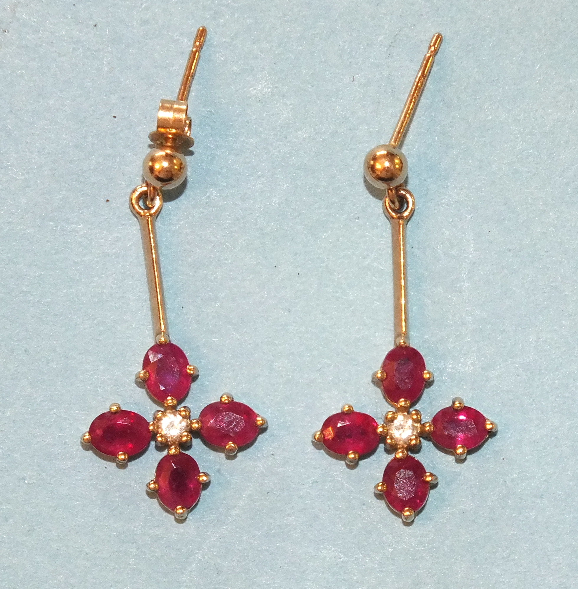 A pair of modern ruby and diamond drop earrings, each claw-set four rubies and a brilliant-cut