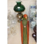 A brass oil lamp with green glass shade, a modern carved wooden parrot and a fencing foil, (3).