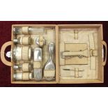 A leather vanity case containing bottles, brushes, etc, with silver-plated mounts.
