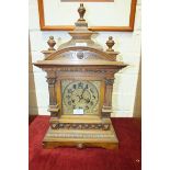 A walnut-cased mantel clock of architectural form with brass dial, the movement striking on a