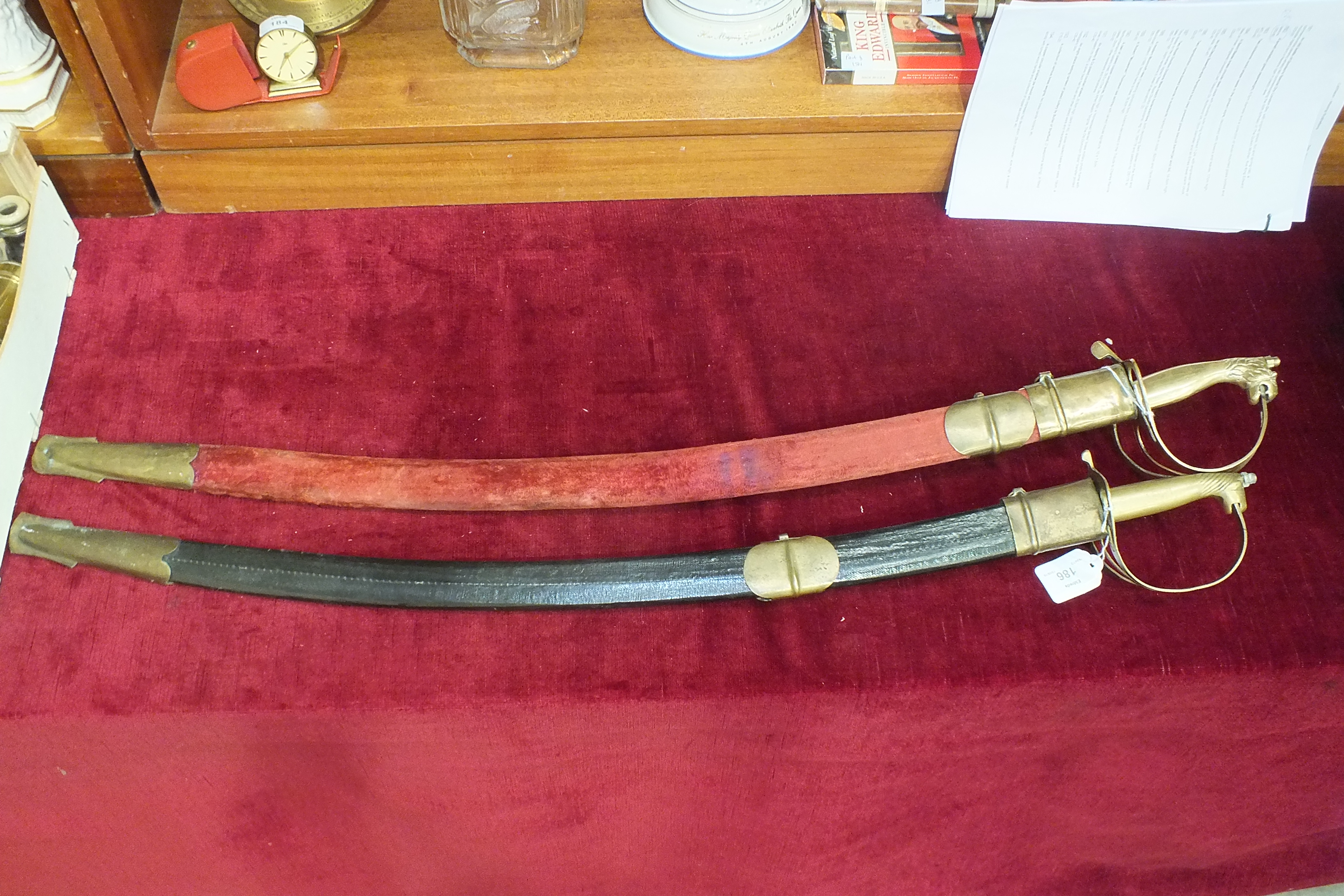 Two reproduction curve-bladed swords in scabbards marked 'Made in India', 82cm and 79cm blades, (