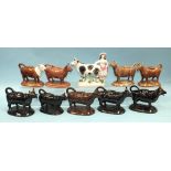 A collection of four Staffordshire-style ceramic cow creamers, with black and gilt-decorated body,