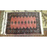 A collection of four modern Eastern-style rugs, all decorated pink, black, cream and blue, largest