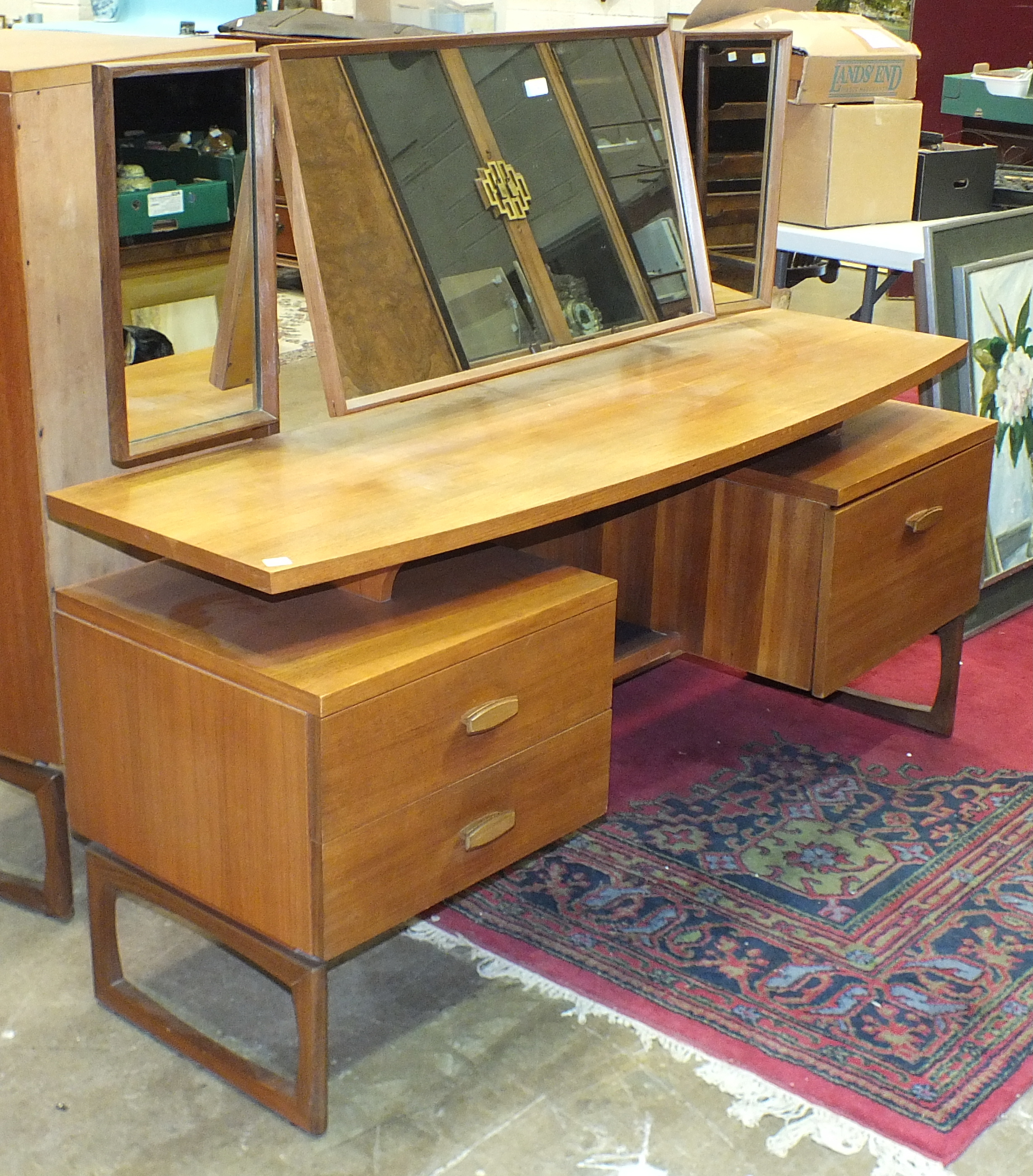 A retro G-Plan triple-mirrored light teak dressing table fitted with two drawers and a cupboard