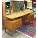 A retro G-Plan triple-mirrored light teak dressing table fitted with two drawers and a cupboard