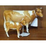 A Beswick Guernsey cow, (first version), 11cm high and a Guernsey calf, 7cm high, (2).